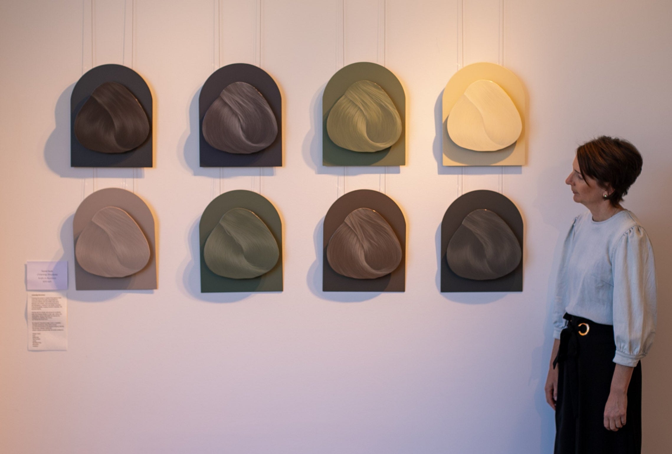 Woman looking at a display of hats on a wallslider_item_JkXxN6
